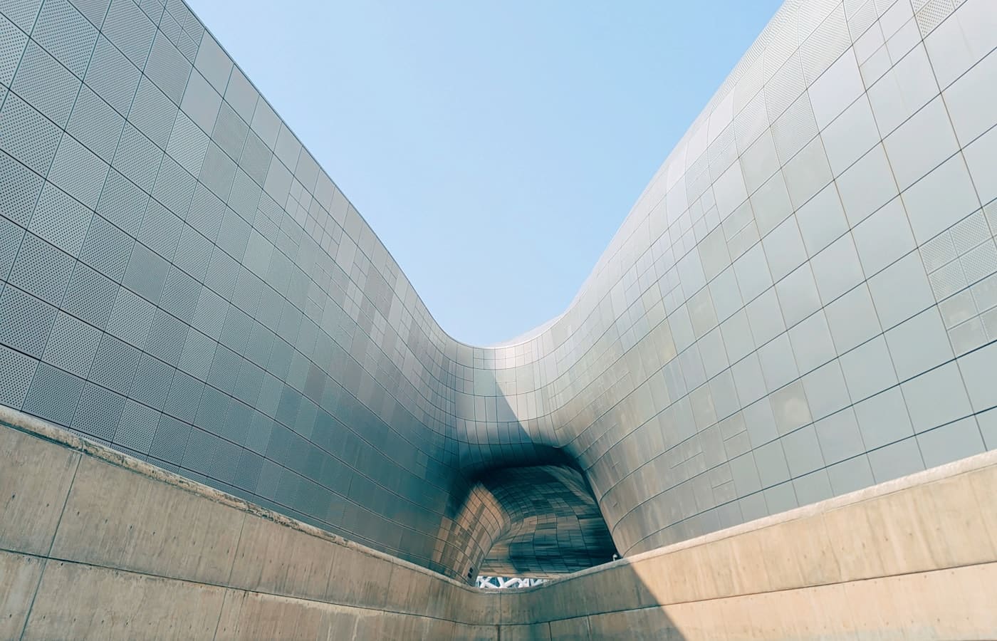 Curved architectural metal facade with repeating panel joints.